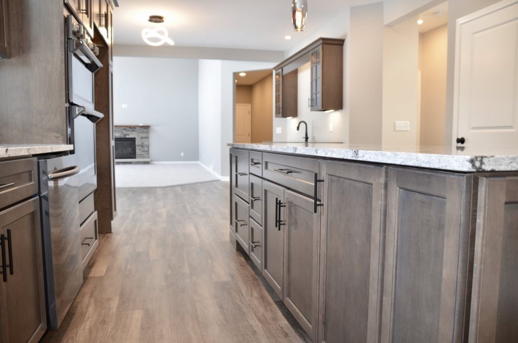 Bradford-Kitchen-Island-with-Quartz-Countertop-Dark-Cabinetry-and-Great-Room-View