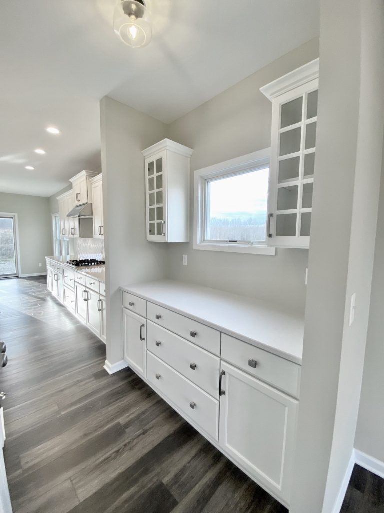 Concord-I-Kitchen-with-Large-Quartz-Island-White-Cabinetry-Pendant-Lights-and-Wall-Oven