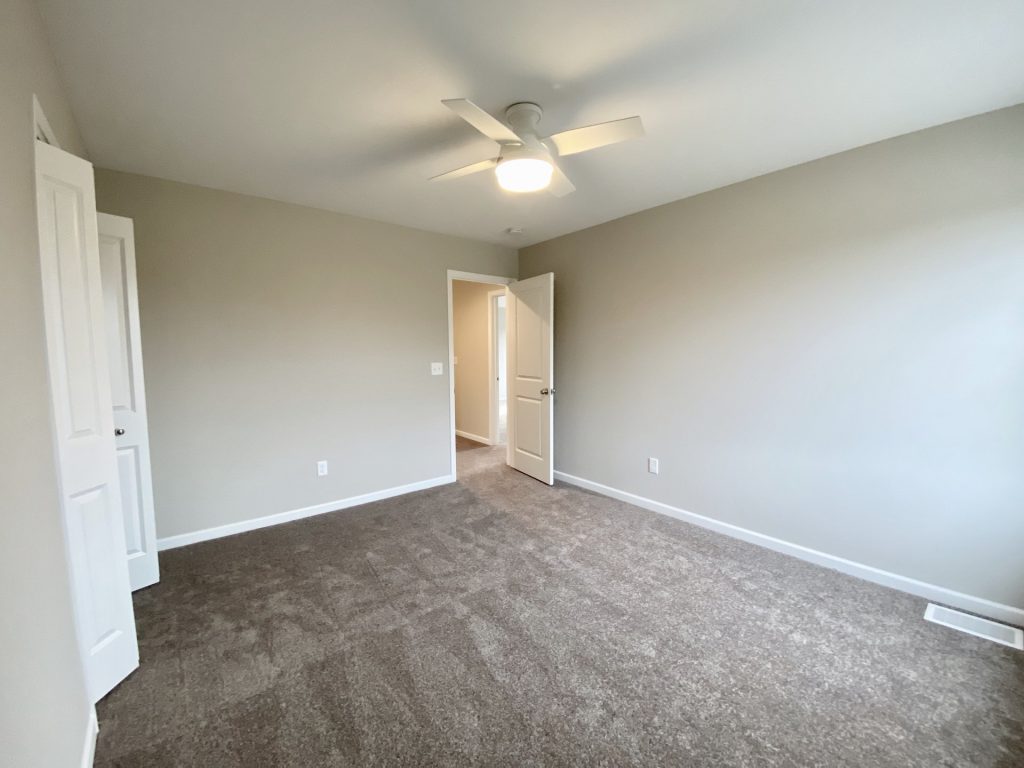 Concord-I-Secondary-Bedroom-with-Neutral-Carpet-White-Ceiling-Fan-and-Hall-Entry-View