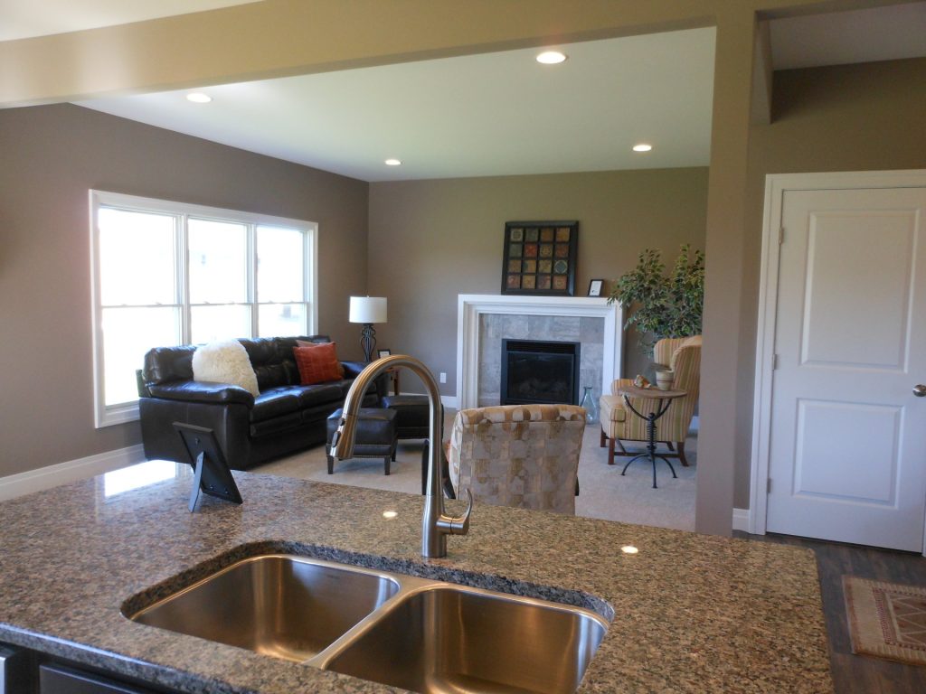 The Concord II Great Room with Fireplace, Double Window, Neutral Carpet & Granite Kitchen Island View