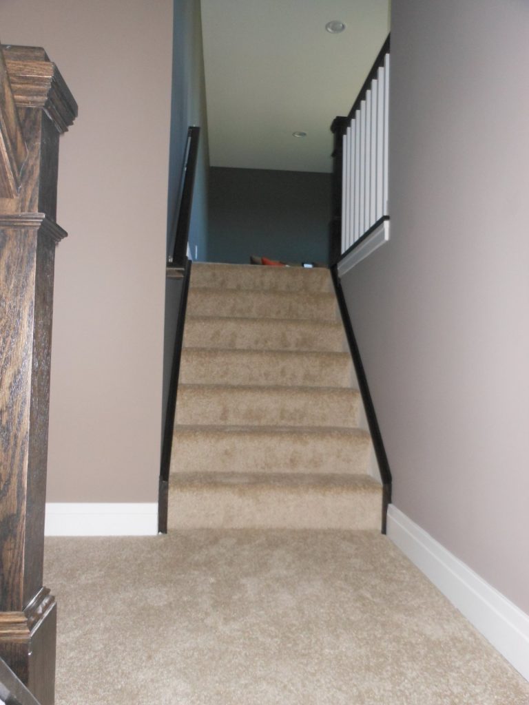 The Concord II Carpeted Staircase with Dark Handrail, White Balusters, Taupe Walls & Upper Loft Landing View