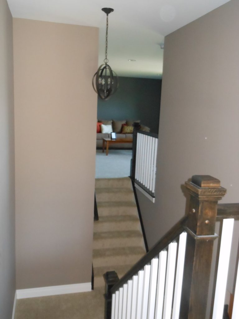The Concord II Stair Hall with Dark Newel Post, White Balusters, Pendant Light & Upper Loft Sitting Area View