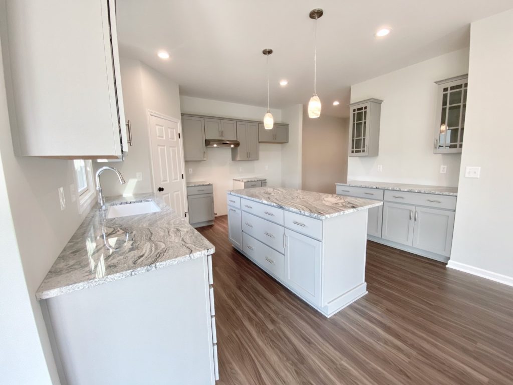 The Forsythe Kitchen with Gray Island, Buffet Cabinets, Quartz Counters, Gray Cabinetry & Pendant Lights