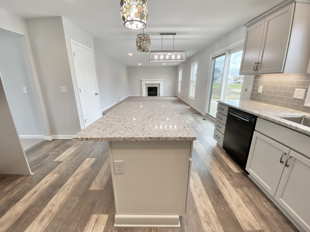 The Mackenzie Great Room with Open Kitchen View, Neutral Carpet, Tall Windows & Kitchen Island