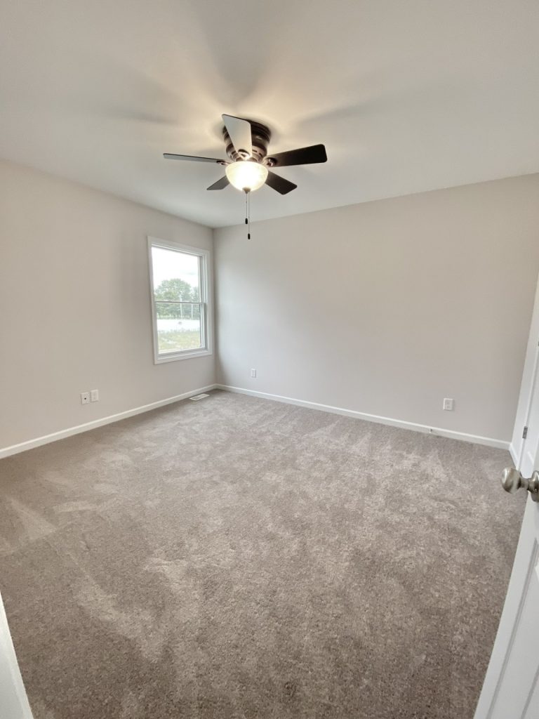 The Mackenzie Secondary Bedroom with Neutral Carpet, Ceiling Fan, Single Window & Light Walls