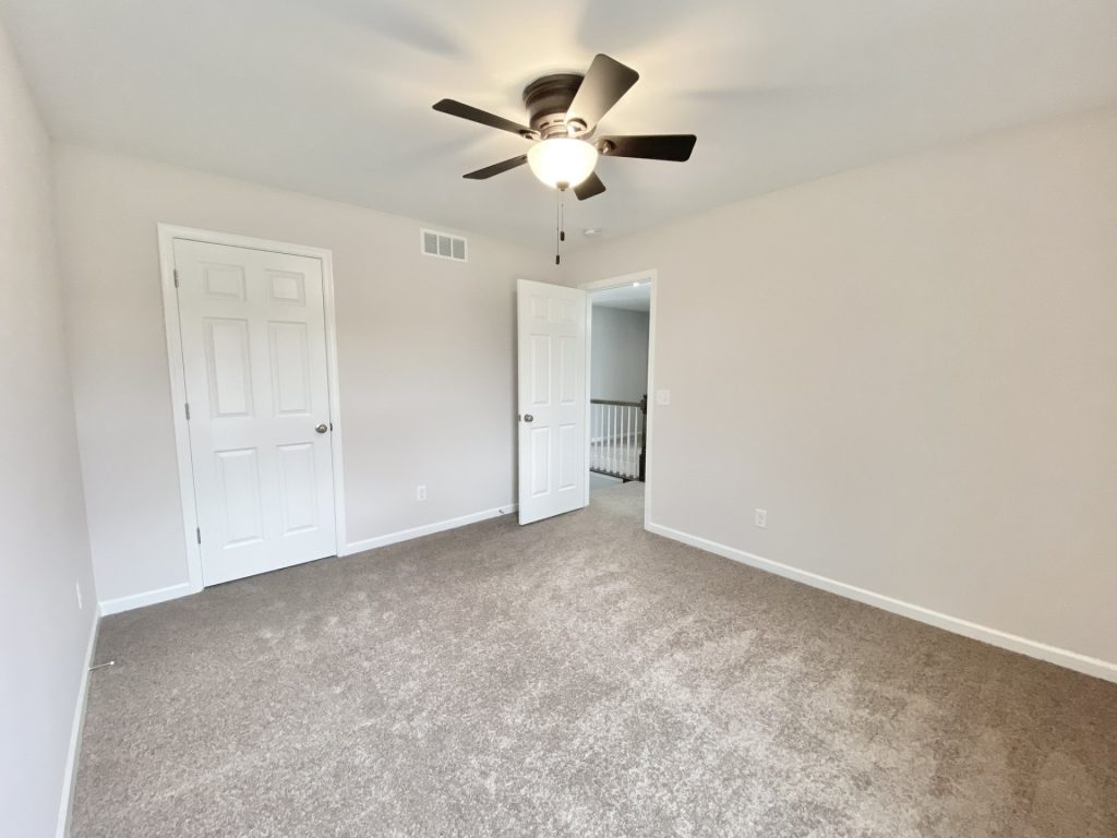 The Mackenzie Secondary Bedroom with Neutral Carpet, Ceiling Fan, Closet Door & Hall Entry