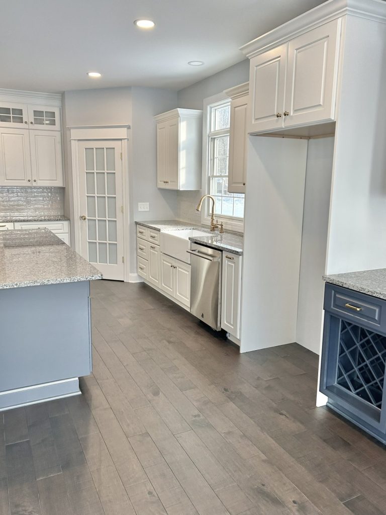 The Maple with Loft Kitchen Sink Wall with White Cabinetry, Window, Refrigerator Nook & Wood-Look Flooring