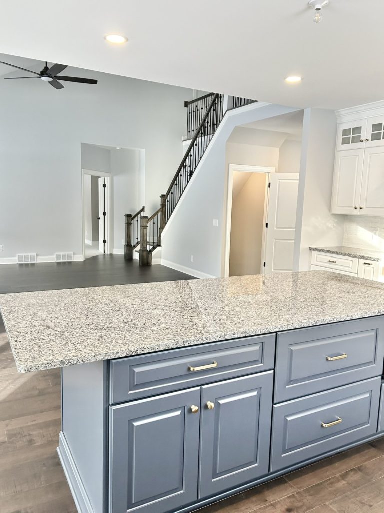 The Maple with Loft Kitchen Island with Quartz Countertop, Staircase View, Open Great Room & Wood-Look Flooring