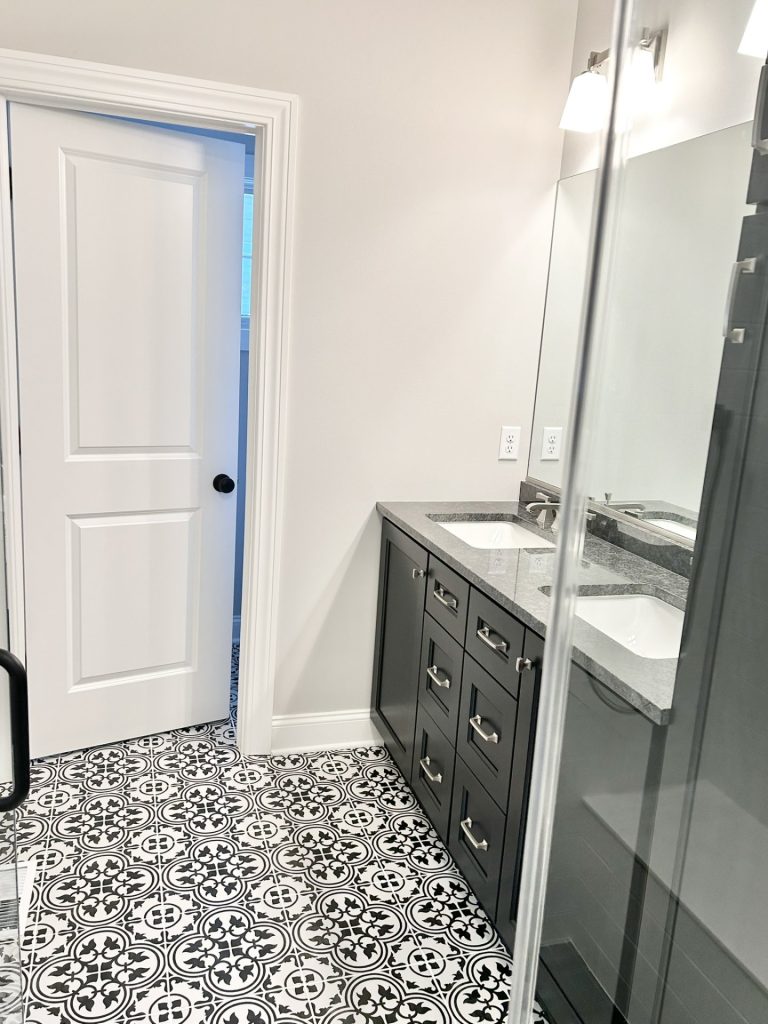 The Maple with Loft Double Vanity with Dark Cabinetry, Large Mirror, Granite Countertop & Patterned Tile Floor