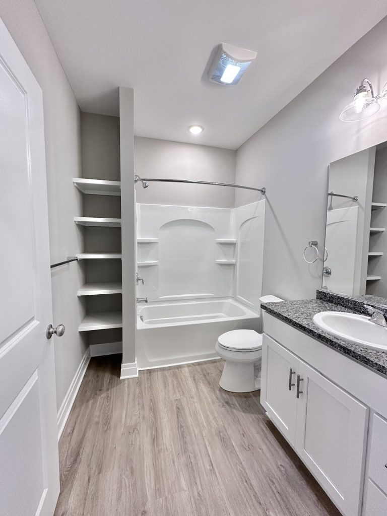 Master-Bath-in-White-Neutrals-with-Vanity-Toilet-Shower-Tub-Combo-and-Built-in-Shelving