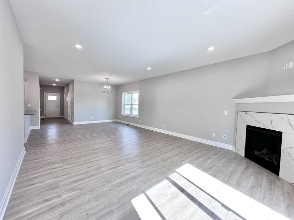 Open-Concept-Living-Dining-Area-with-Modern-Fireplace-in-White-Neutrals-with-Recessed-Lighting-Window-and-Entry