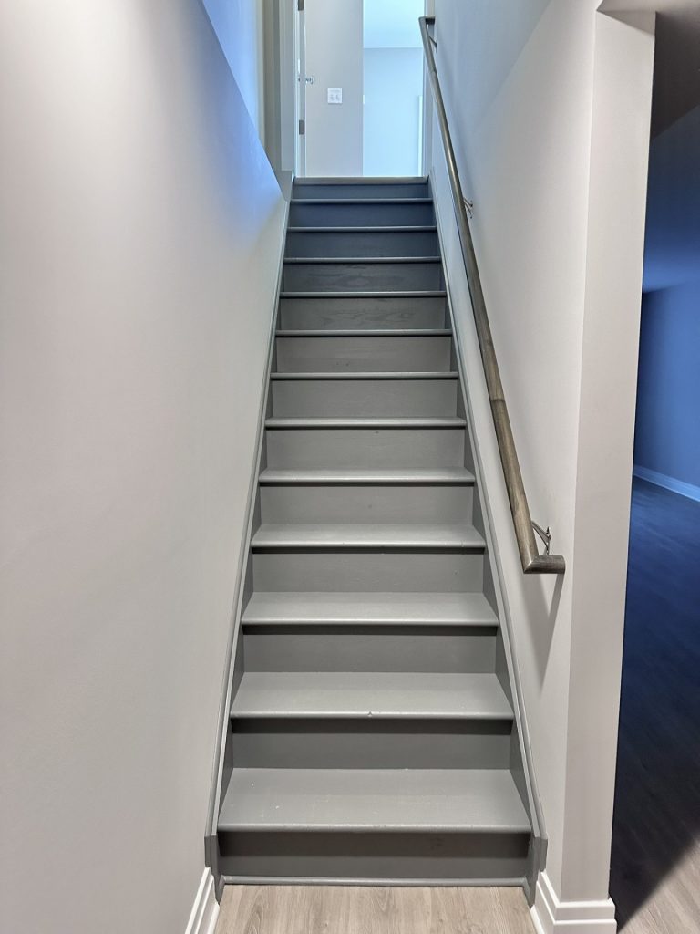 Madison-Painted-Staircase-with-Gray-Treads-Wood-Look-Flooring-and-Interior-Hall-View