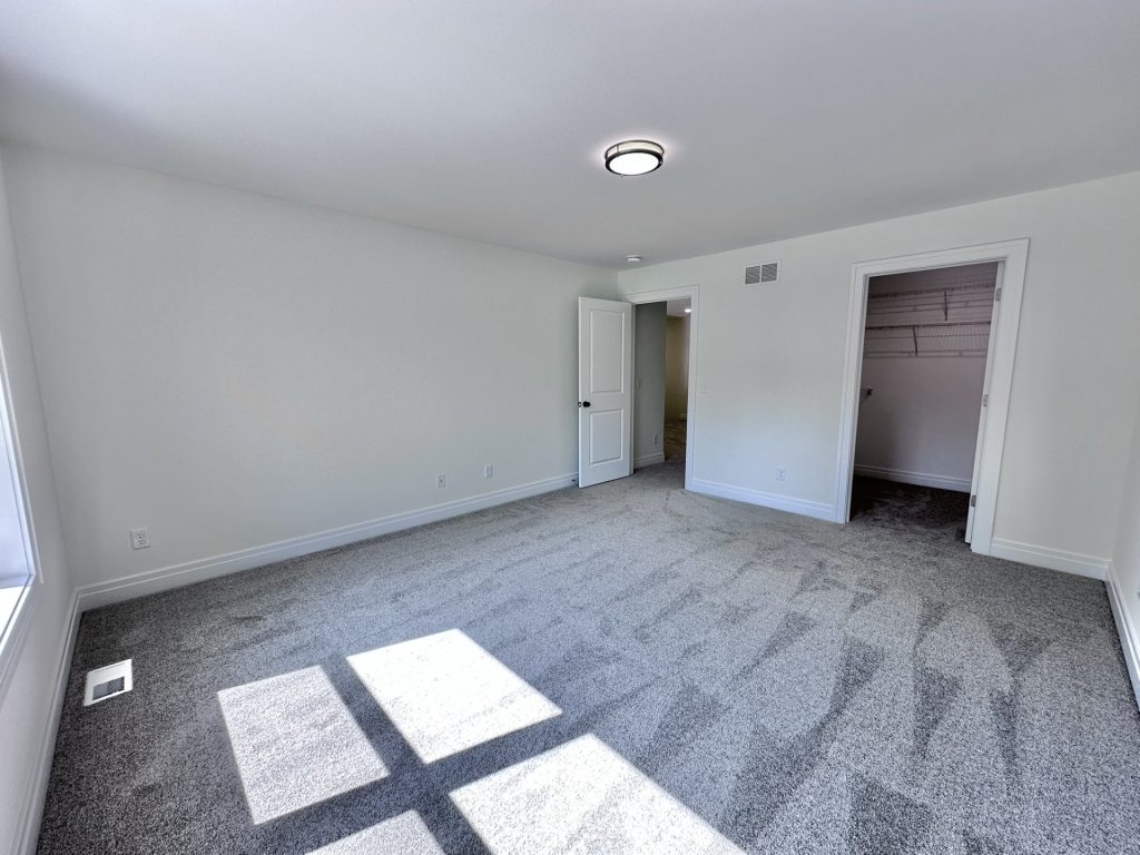 Madison-Secondary-Bedroom-with-Gray-Carpet-Walk-In-Closet-Entry-and-White-Trim