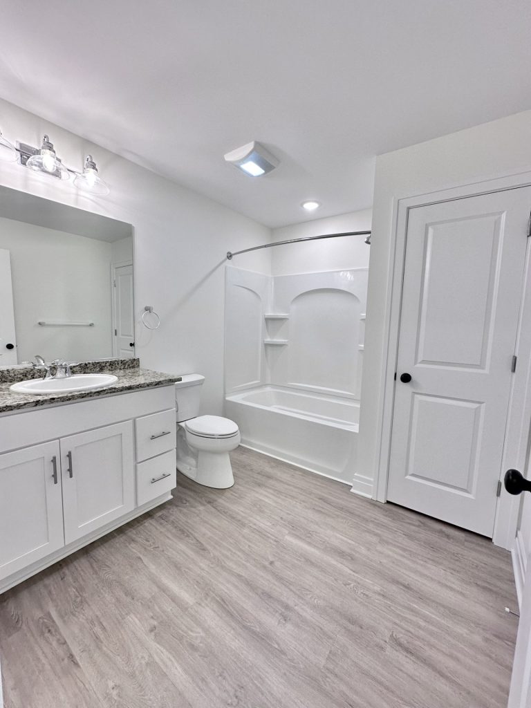 Madison-Main-Bathroom-with-Granite-Vanity-Top-Tub-Shower-Combo-and-Wood-Look-Flooring