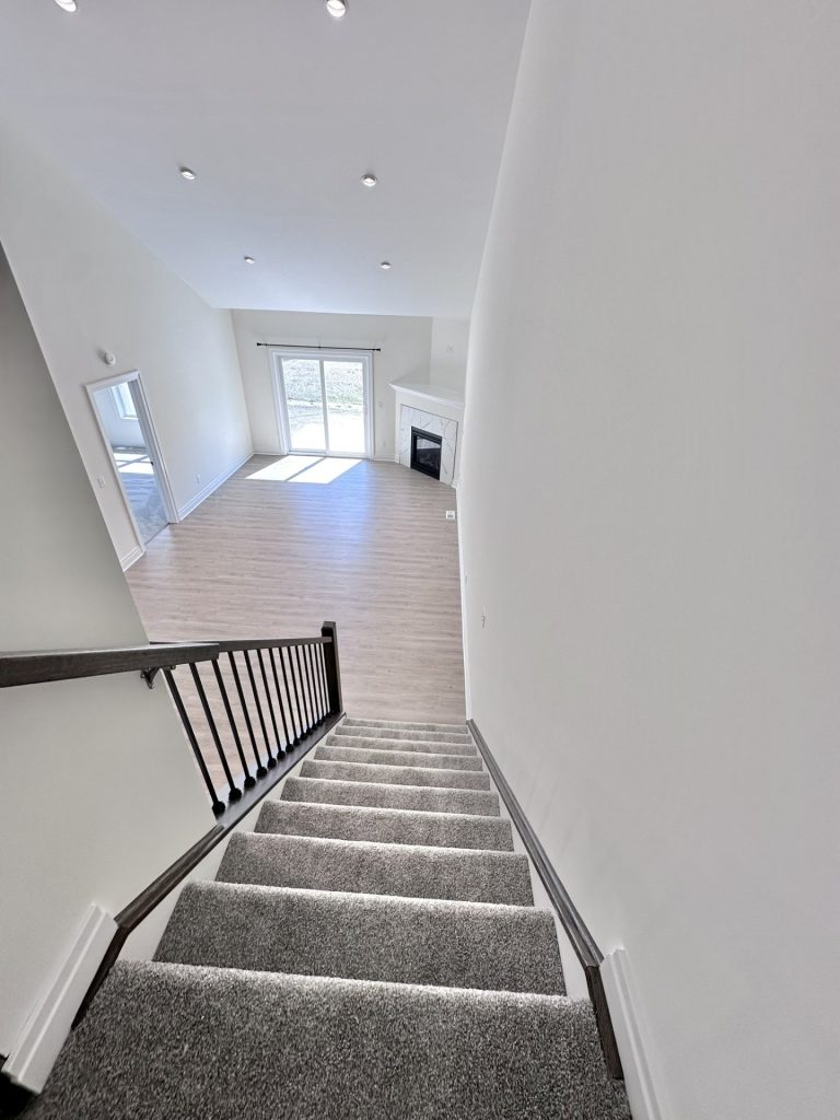Madison-Staircase-View-from-Loft-with-Carpeted-Steps-Black-Railing-and-Great-Room-Below