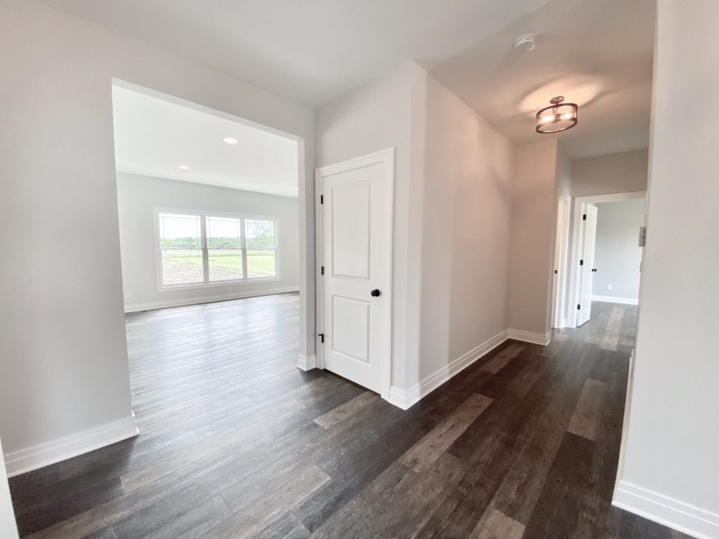 The Golden Front Hallway with Wood-Look Flooring, White Doors, Neutral Walls & Great Room View