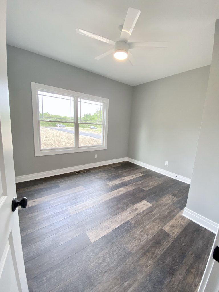 The Golden Bedroom with Wood-Look Flooring, Gray Walls, White Ceiling Fan & Double Window