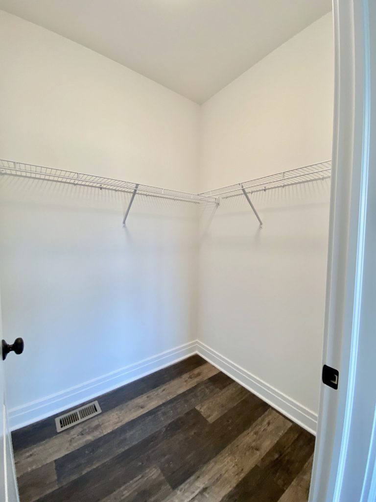 The Golden Walk-In Closet with Wire Shelving, White Walls & Wood-Look Flooring