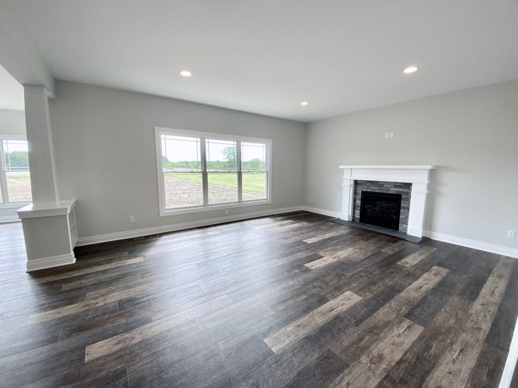 The Golden Great Room with Fireplace, Large Window, Recessed Lighting & Wood-Look Flooring
