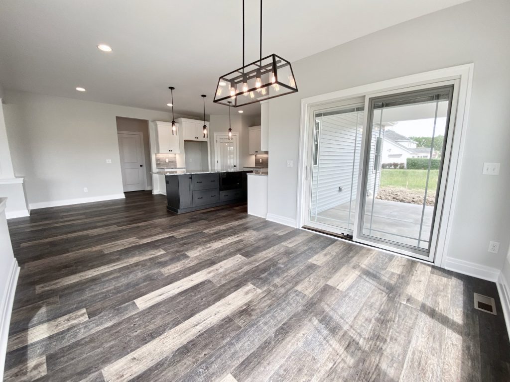The Golden Dinette with Sliding Glass Door, Linear Chandelier, Kitchen View & Wood-Look Flooring