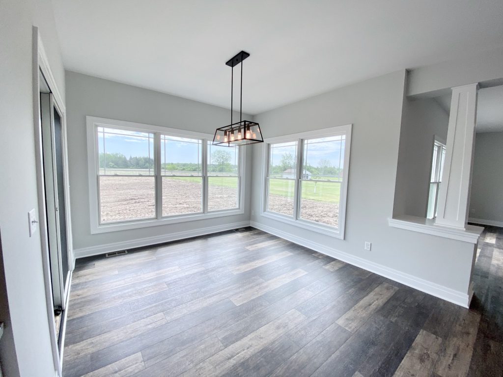 The Golden Dinette with Corner Windows, Linear Chandelier, Wood-Look Flooring & Open Layout