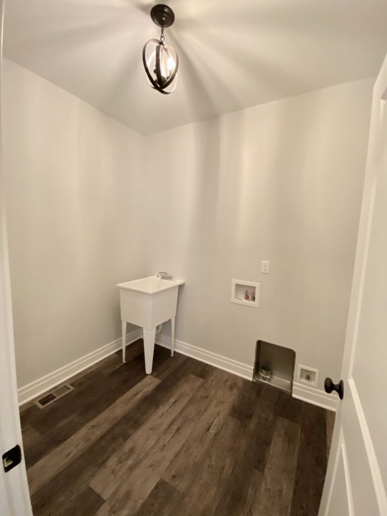 The Golden Laundry Room with Utility Sink, Wood-Look Flooring, White Walls & Laundry Hookups