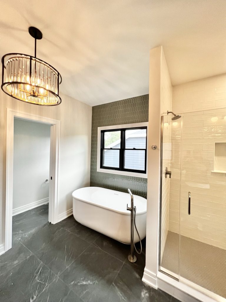 The Cedar Freestanding Tub with Glass Shower, Accent Tile Wall, Dark Tile Flooring & Toilet Room Entry