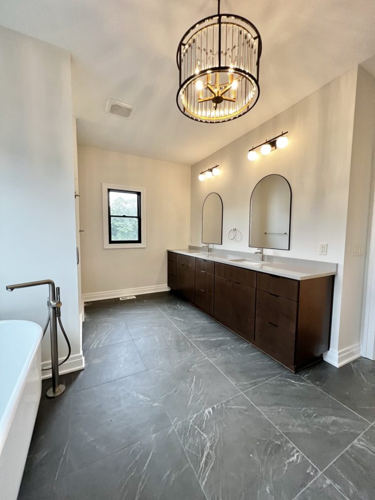The Cedar Double Vanity with Dark Cabinetry, Arched Mirrors, Quartz Countertop & Dark Tile Flooring