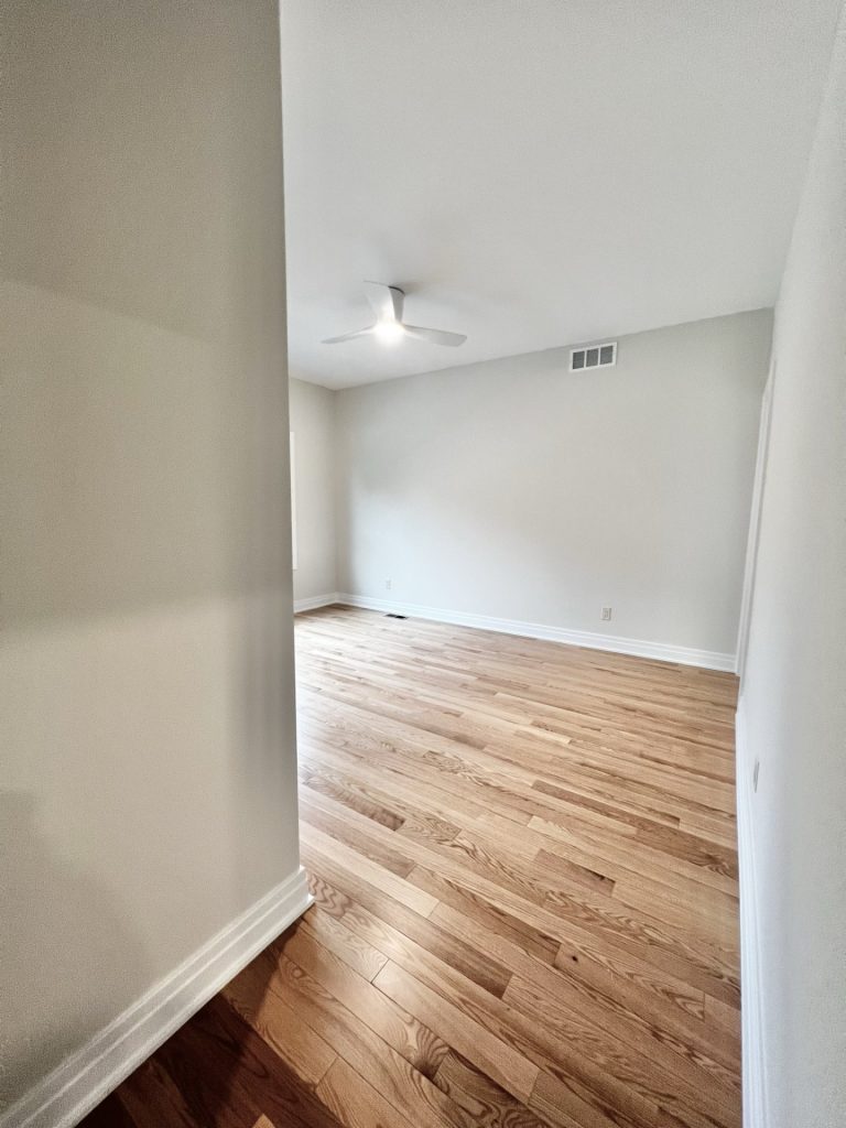 The Cedar Bedroom Entry with Hardwood Flooring, Ceiling Fan, Neutral Walls & Open Doorway