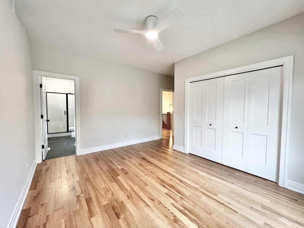 The Cedar Bedroom with Hardwood Flooring, Ceiling Fan, Double Closet Doors & Bathroom Entry