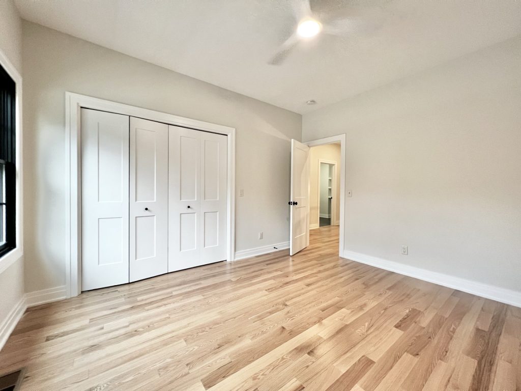 The Cedar Bedroom with Hardwood Flooring, Ceiling Fan, Double Closet Doors & Neutral Walls