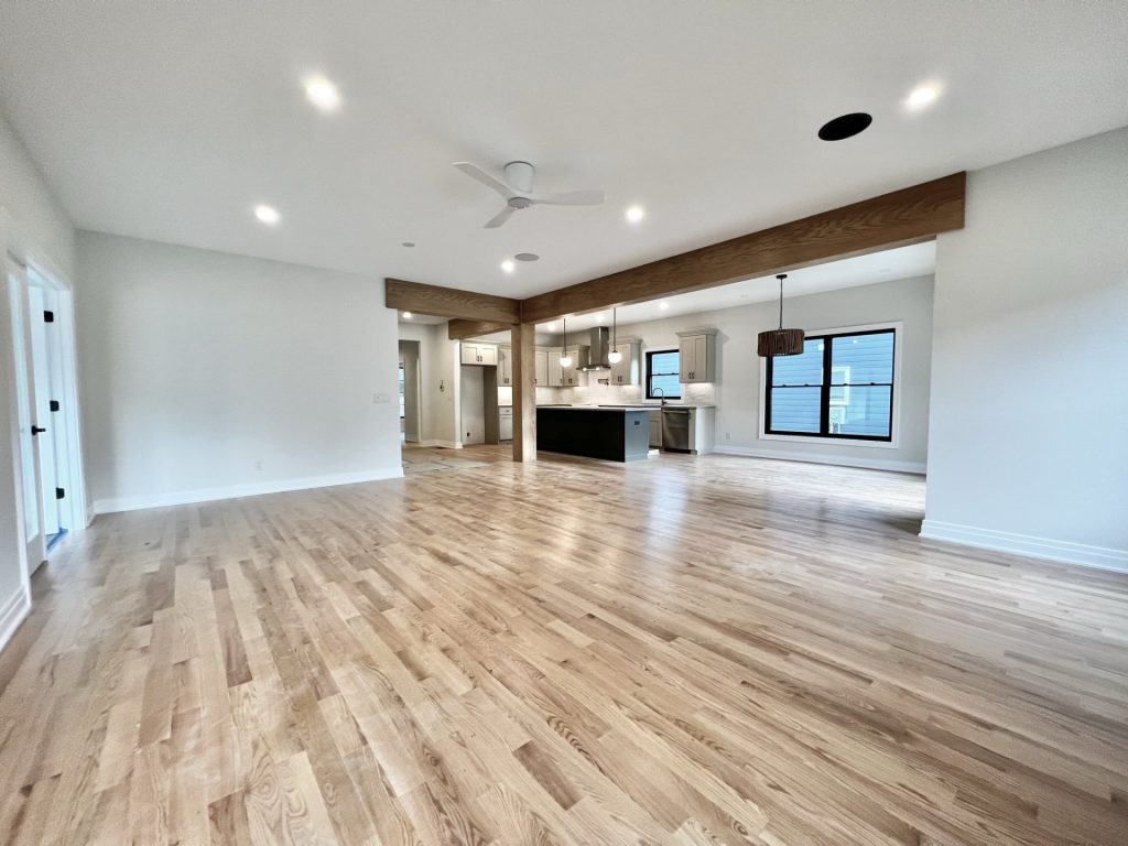 The Cedar Open Great Room and Kitchen with Wood Beams, Large Island, Wide Layout & Hardwood Flooring