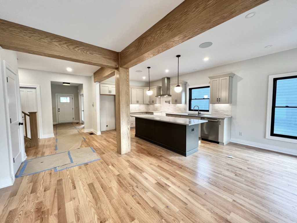 The Cedar Kitchen with Large Island, Wood Beam Detail, Quartz Counters & Hardwood Flooring