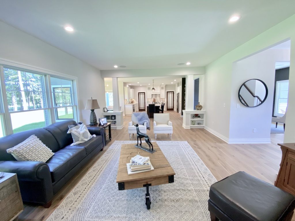 The Ruskin 2.0 Great Room with Picture Windows, Wood-Look Flooring, Large Rug & Open Kitchen View