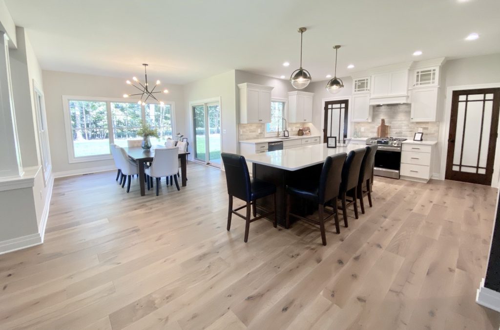 The Ruskin 2.0 Kitchen and Dining Area with Large Island, White Cabinetry, Large Picture Window & Wood-Look Flooring