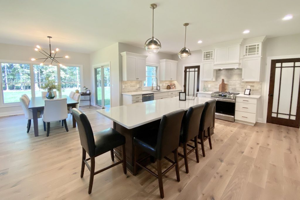 The Ruskin 2.0 Kitchen with Oversized Island, White Cabinetry, Pendant Lights, Tile Backsplash & Wood-Look Flooring