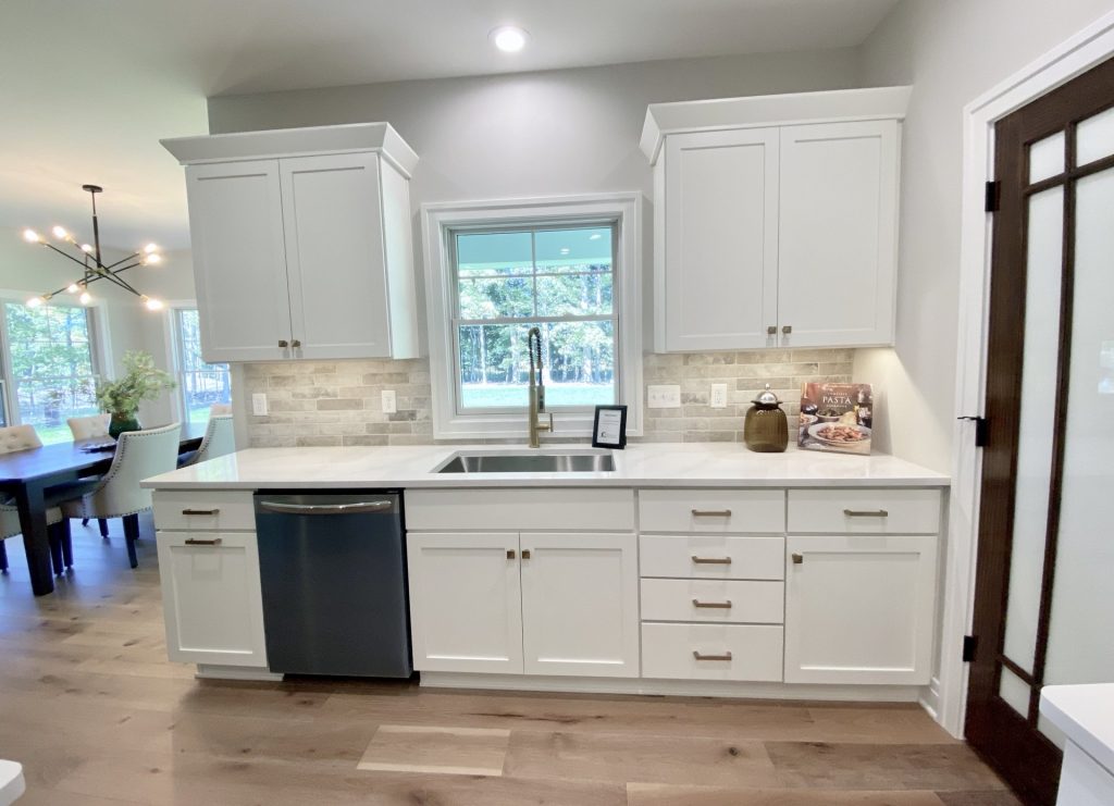 The Ruskin 2.0 Kitchen Sink Wall with White Cabinetry, Window, Quartz Counters & Tile Backsplash