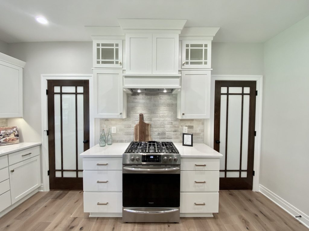 The Ruskin 2.0 Kitchen Range Wall with White Cabinetry, Decorative Hood, Tile Backsplash & Frosted Glass Doors
