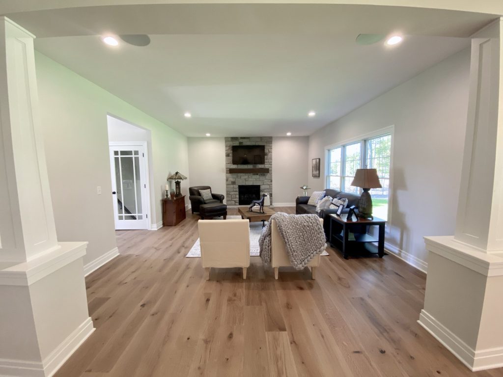 The Ruskin 2.0 Great Room with Stone Fireplace, Seating Area, Wood-Look Flooring & Wide Opening to Kitchen