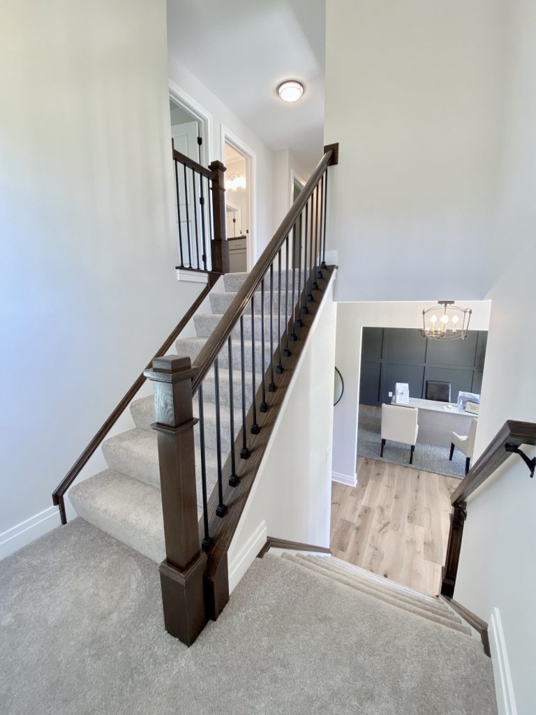 The Ruskin 2.0 Staircase from Upper Landing with Dark Railings, Neutral Carpet & Study View Below