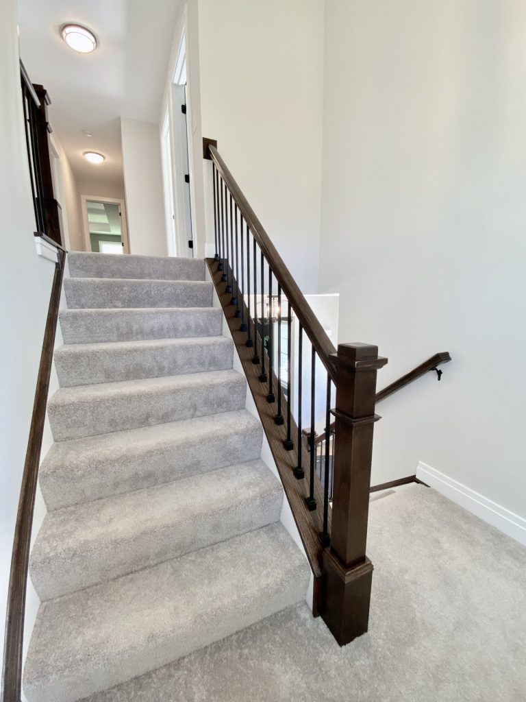 The Ruskin 2.0 Upper Stair Landing with Carpeted Steps, Dark Balusters & Neutral Walls