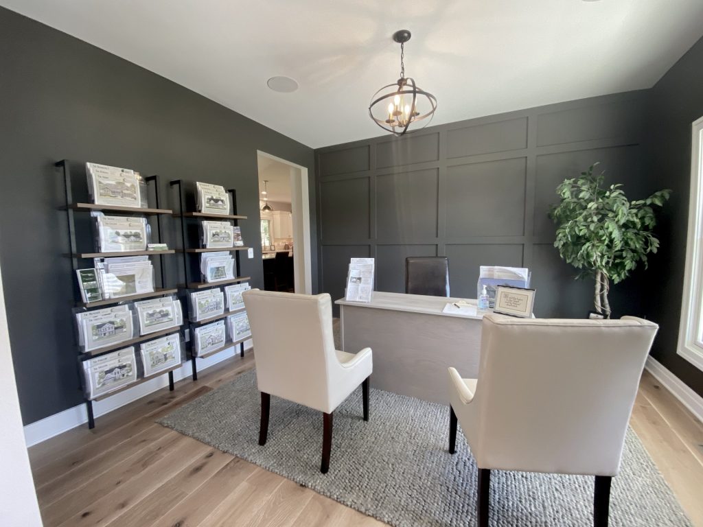 The Ruskin 2.0 Front Study with Dark Accent Walls, Wood-Look Flooring, Modern Chandelier & Display Shelving