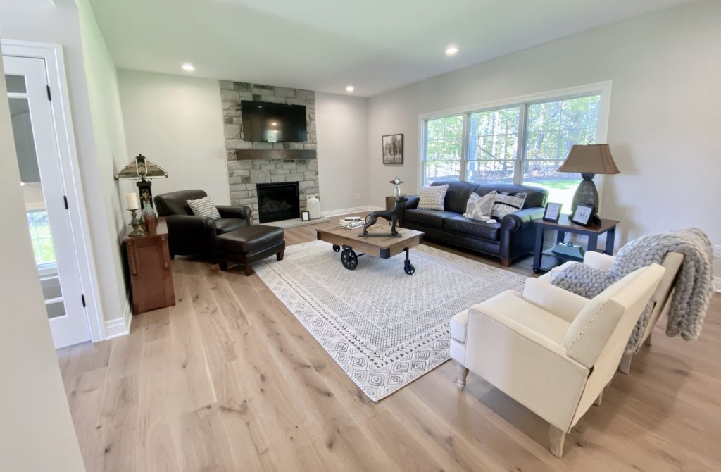 The Ruskin 2Great Room with Stone Fireplace, Large Windows and Wood-Look Flooring