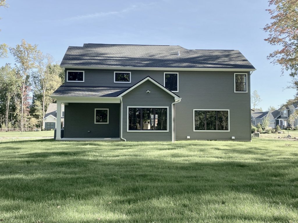 The Ruskin 2.0 Rear Elevation with Covered Porch, Large Windows, Gray Siding & Backyard View