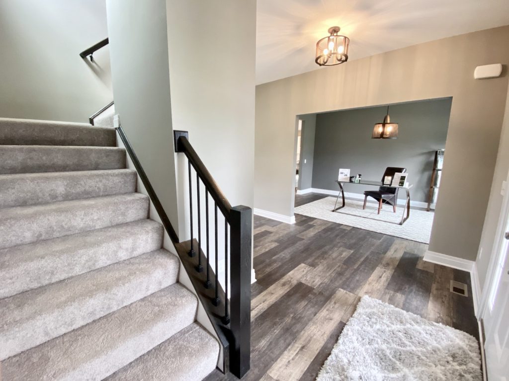 The Weston Front Staircase with Carpeted Steps, Dark Handrail, Black Balusters & Dining Room View