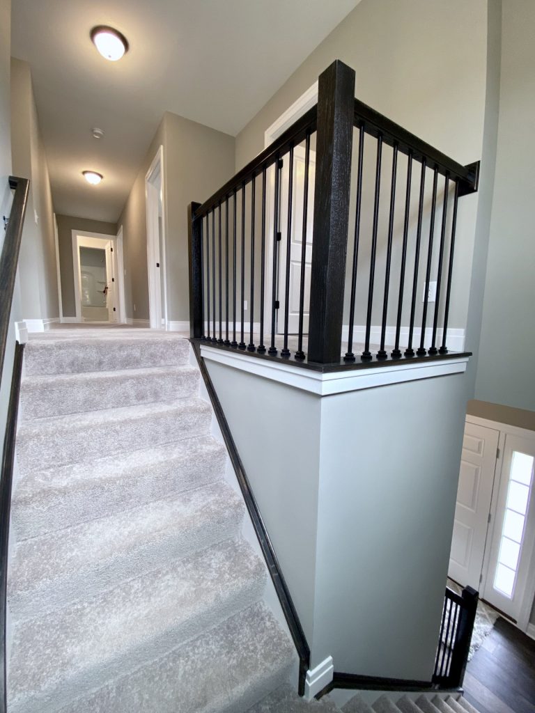 The Weston Stair Landing with Black Balusters, Window, Carpeted Steps & Pendant Light