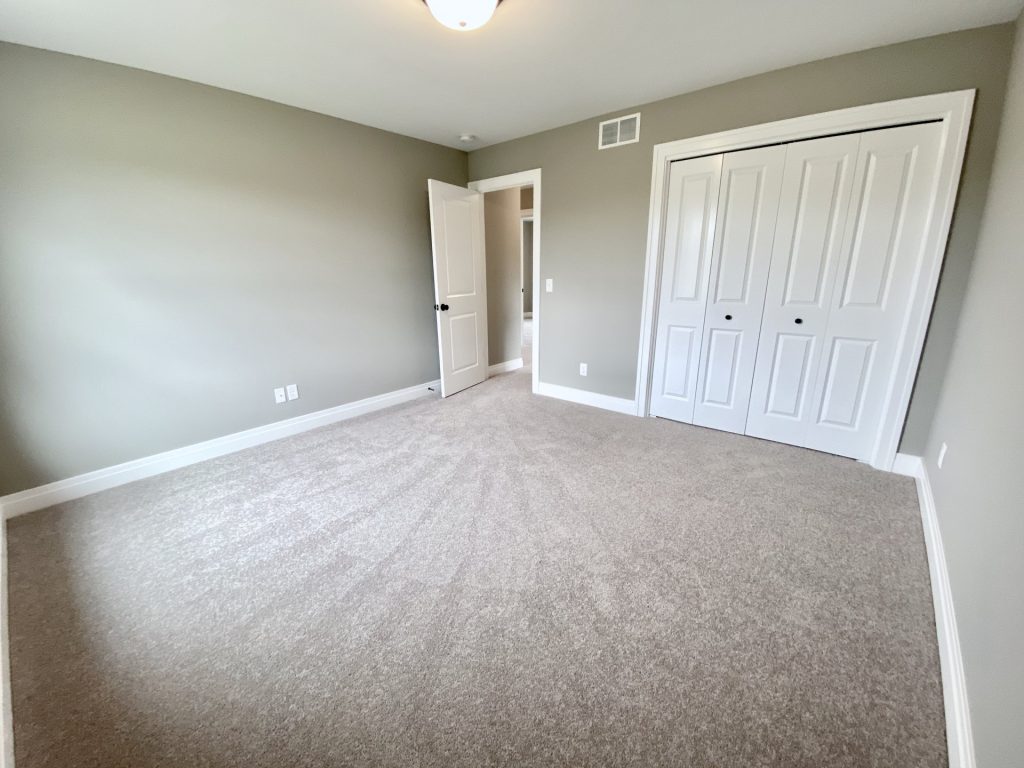 The Weston Secondary Bedroom with Neutral Carpet, Double Closet Doors, Hallway Entry & Olive-Gray Walls