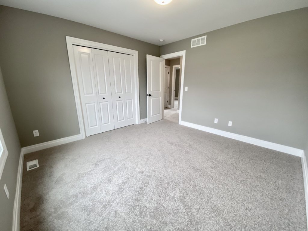 The Weston Secondary Bedroom with Neutral Carpet, Double Closet Doors, Olive-Gray Walls & White Trim