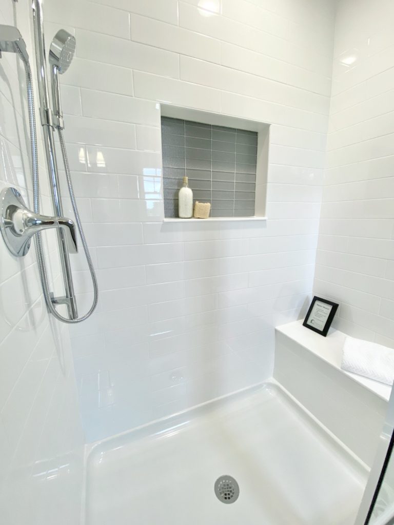 The Weston Shower Niche Detail with Gray Accent Tile, White Surround, Bench Seat & Glass Enclosure
