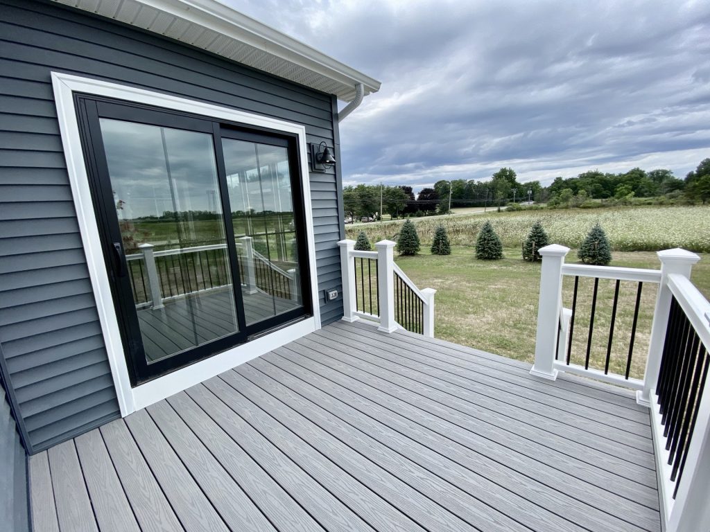 The Weston Rear Porch with Sliding Glass Door, Gray Decking, White Railings & Backyard View